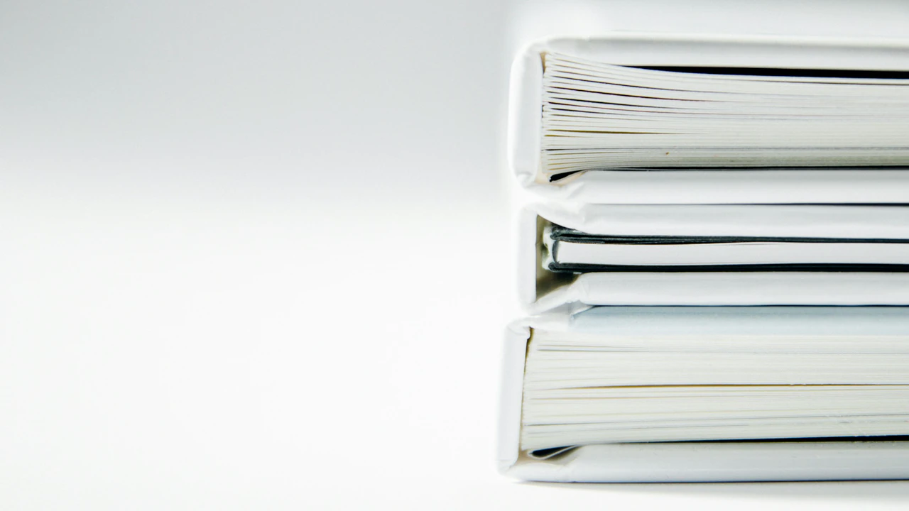 Policy binders on a shelf, tabs out, one page marked.